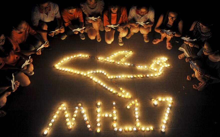 MH17 tragedijos vietoje žmonės neša vainikus ir stato kryžius