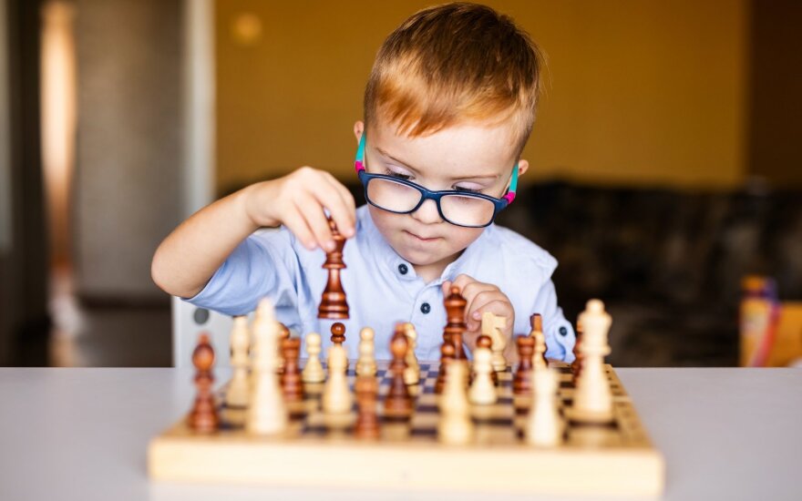 Vaikas žaidžia šachmatais.
